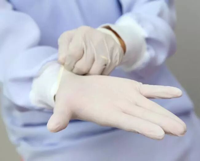 laborantin qui enfile des gants jetables
