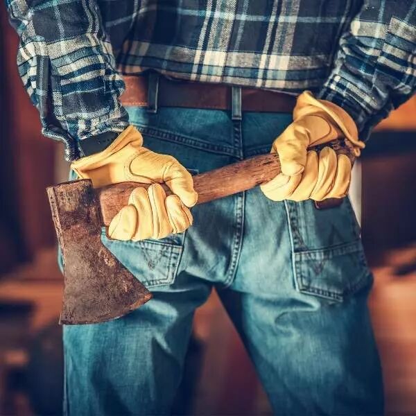 Homme avec gants tenant une hache