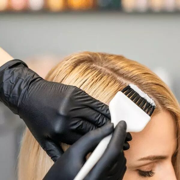Coiffeur �talant du colorant sur cheveux avec gants noirs