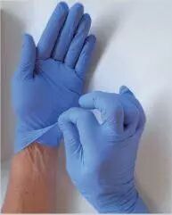 main enlevant un gant jetable 