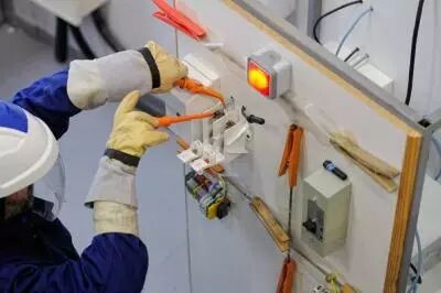 photo homme travaillant dans une armoire électrique