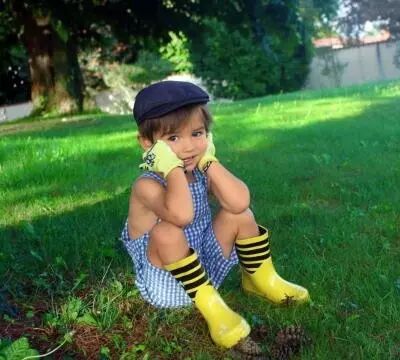 photo petit garçon assis dans l'herbe